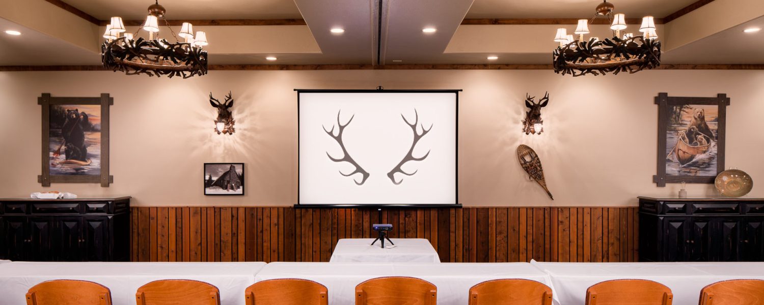 Conference room with rows of chairs and a screen